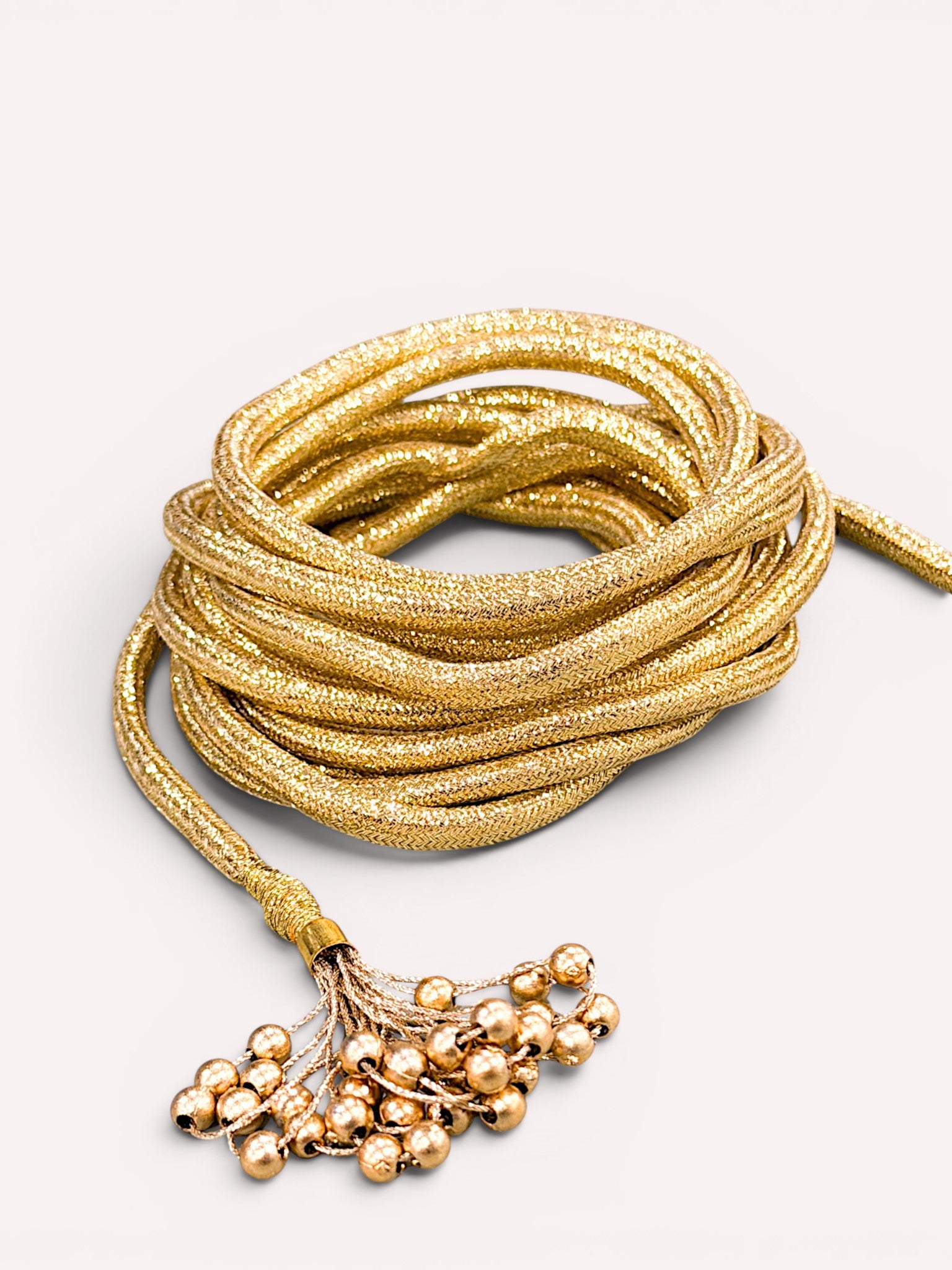 Close-up of delicate metallic bead clusters on the belt ends