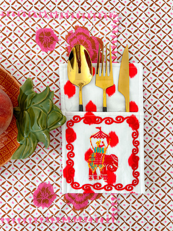 Close-up of hand-printed red ikat dots and ornamental embroidery