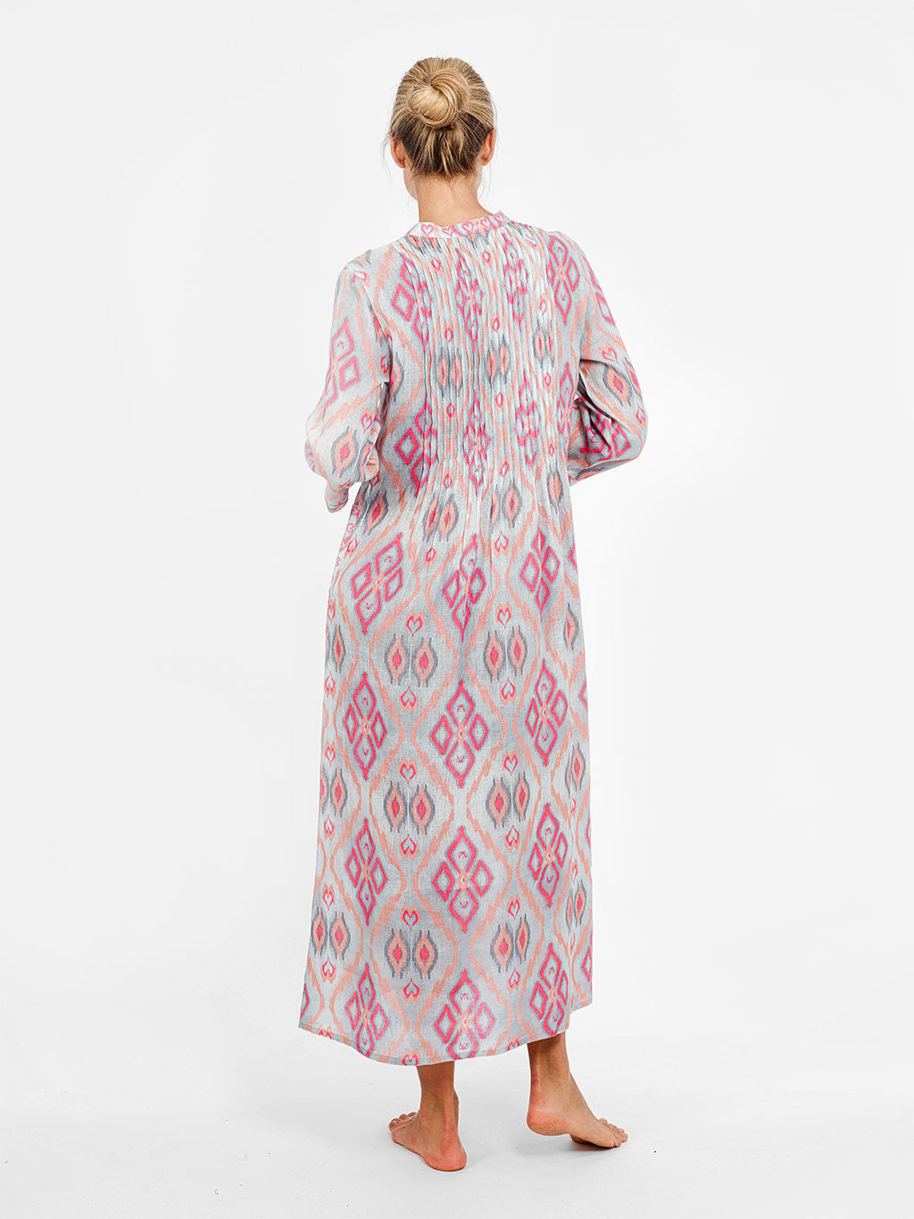 Rear view of the Woodruff dress showcasing the rhythmic pleats and the fluid drape of the premium linen fabric.