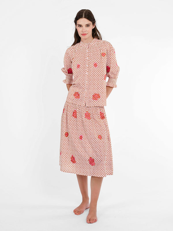 Model wearing the airy Bergamot summer blouse in with pink peony embroidery and a smocked mock neck.