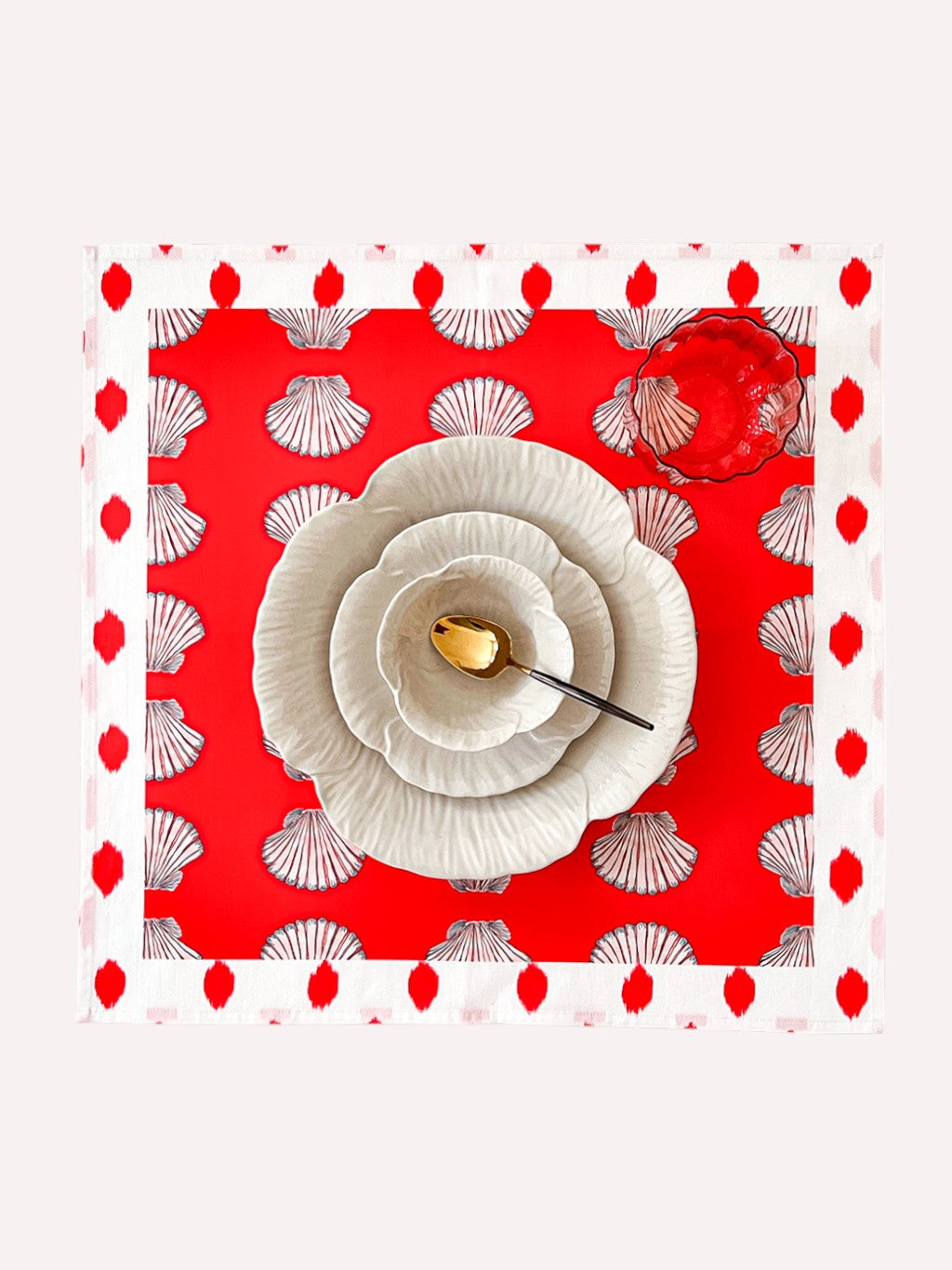 Shells on red organic cotton napkin with decorative dot border by Nimo With Love