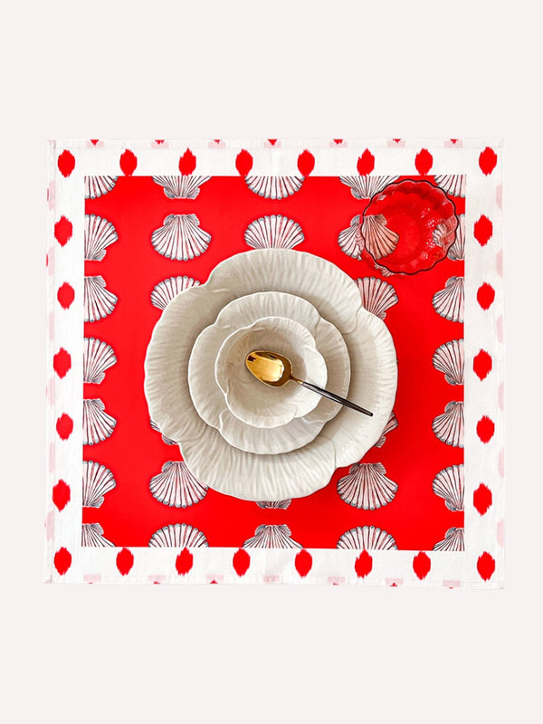 Shells on red organic cotton napkin with decorative dot border by Nimo With Love