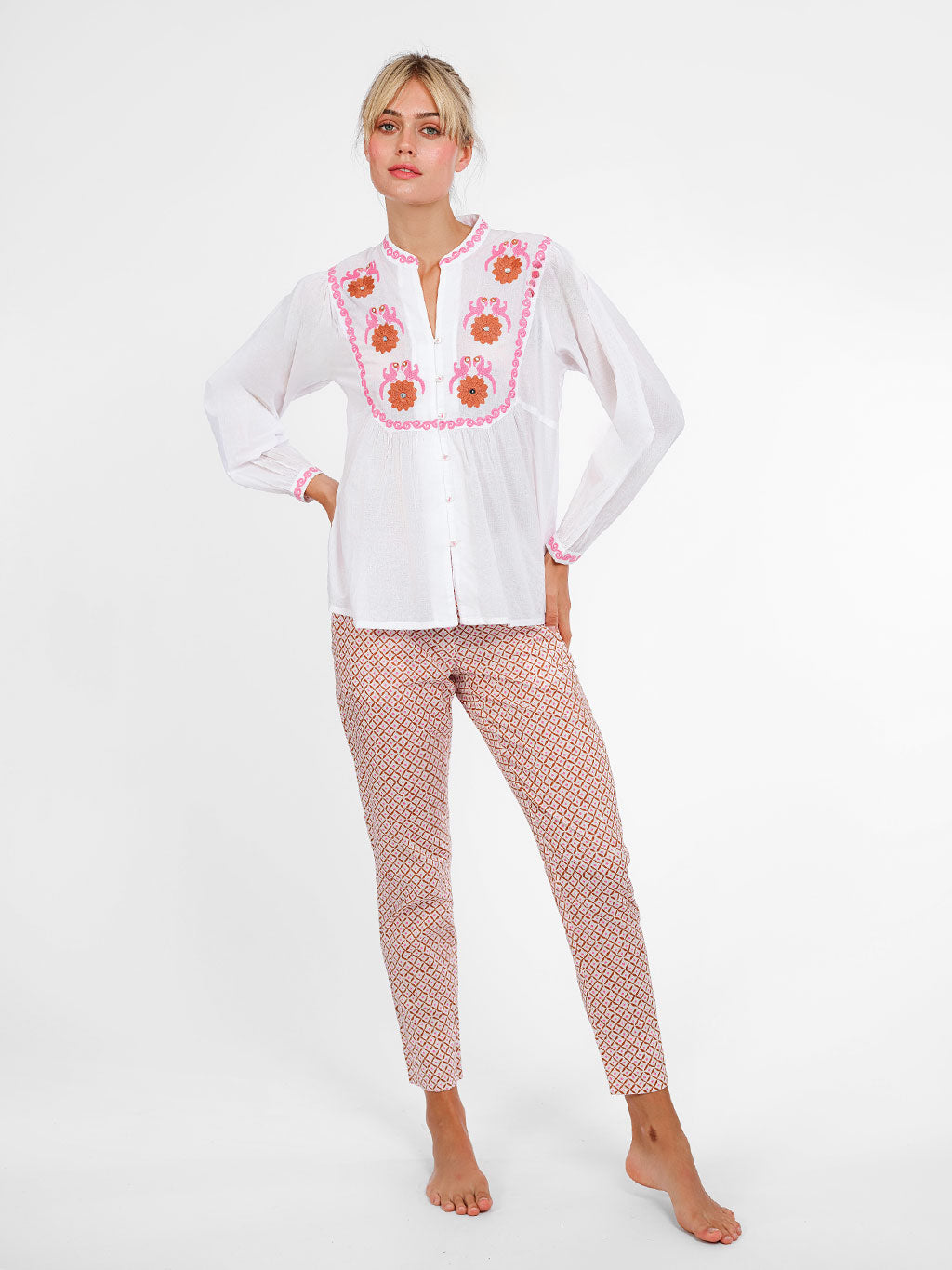 White organic cotton Catnep blouse by Nimo With Love featuring vibrant bird and floral embroidery on the front yoke.