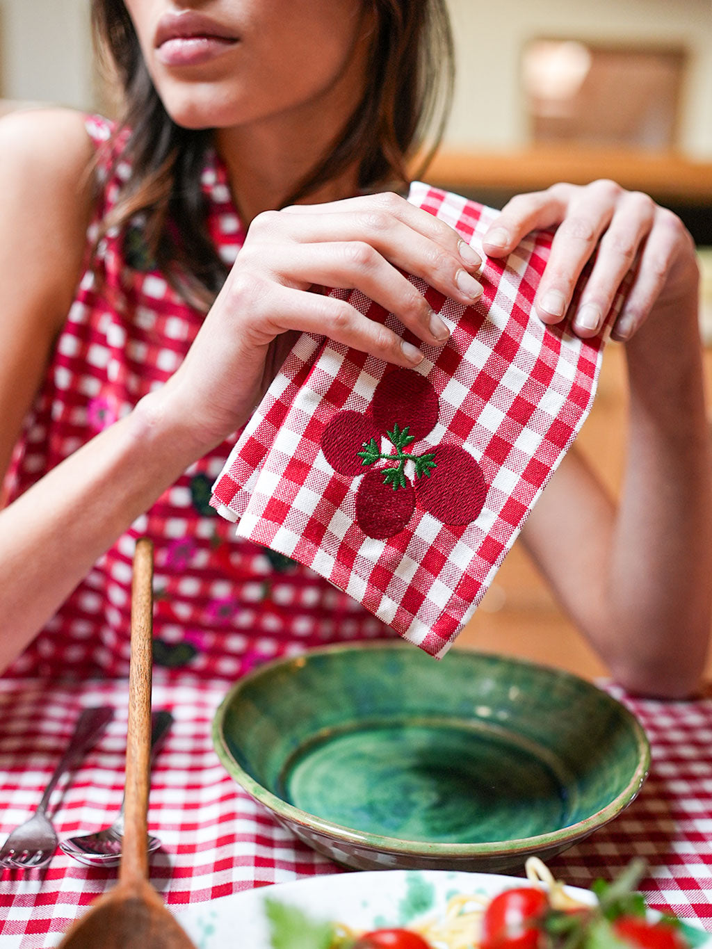 Close-up of the intricate hand-guided 'Amore' and floral embroidery on Nimo's high-end organic cotton gingham fabric.
