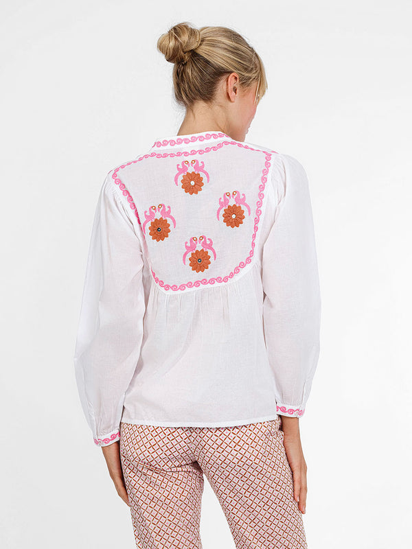 The stunning back view of the Catnep blouse showcasing a large-scale, colorful hand-guided embroidery of birds and flowers.